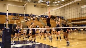 An opposite hitter attempts a block in a volleyball match
