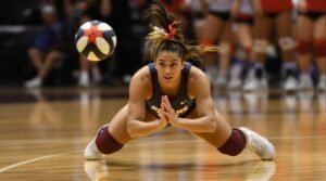 A defensive specialist in a volleyball game dives to return a volleyball