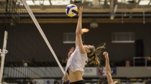 A female outside hitter volleyball player hits the ball in an indoor match